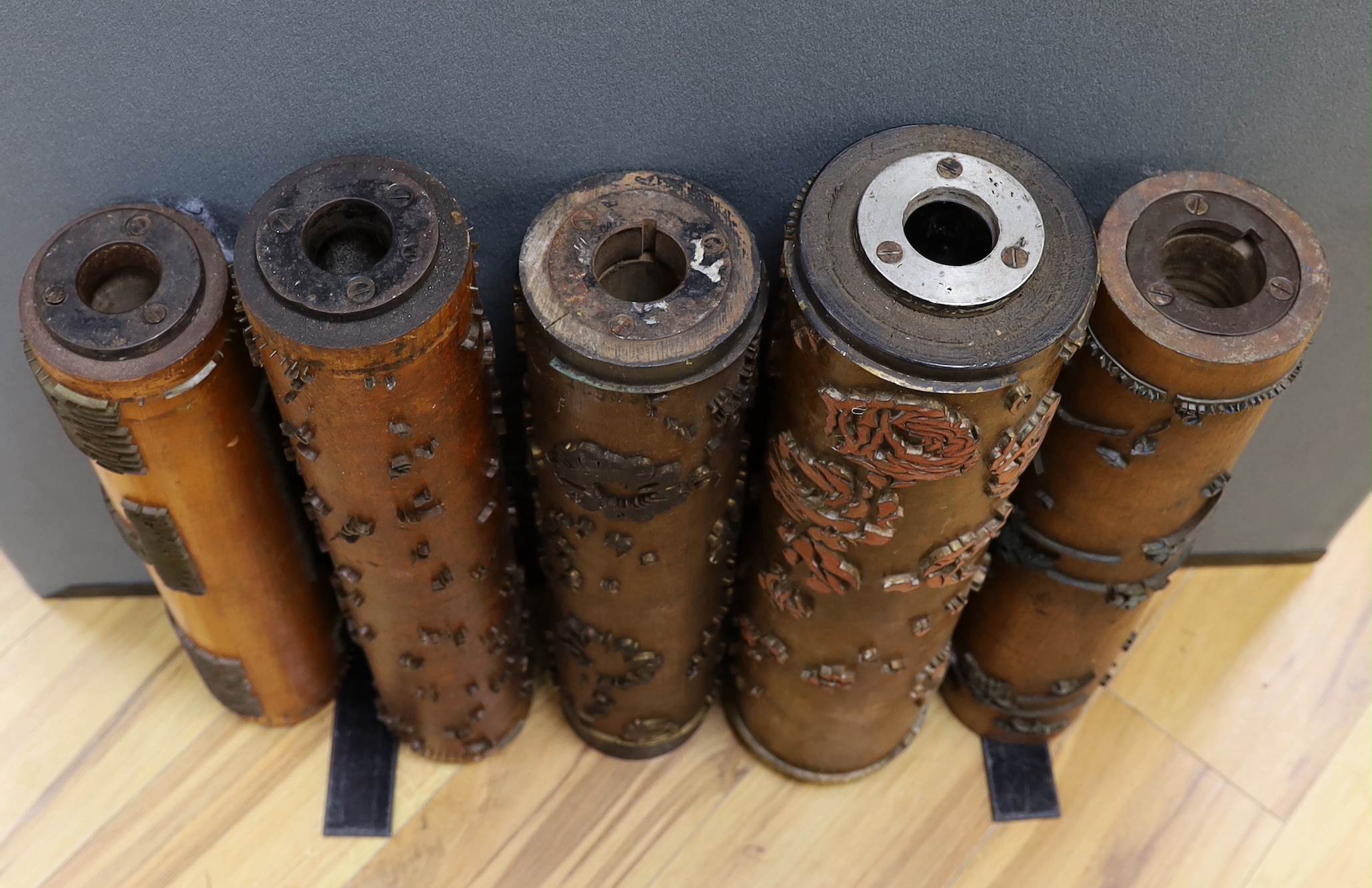Five USA wooden print rollers for wallpaper, late 19th century, including a UWPC (United Wall Paper Craftsmen of North America) example, another stamped with serial numbers, longest 60.5cm